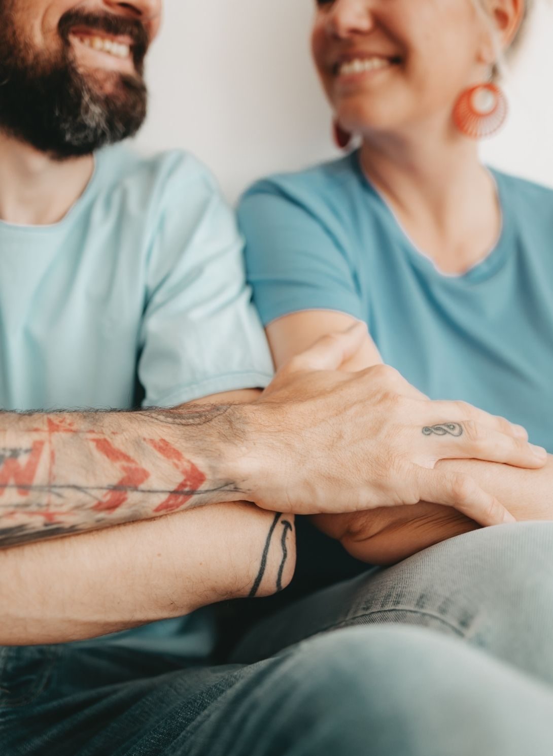 Nahaufnahme eines lächelnden Paares, das sich an den Händen hält – Symbolfoto für Elternsein als Paar im Rahmen der Familienberatung in Salzburg mit Sibylle Paier.
